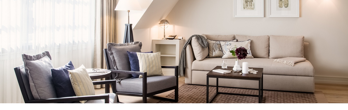 Elegantes Wohnzimmer im Severin*s Resort & Spa mit gemütlicher Couch, Sesseln, Tisch und stilvoller Dekoration.