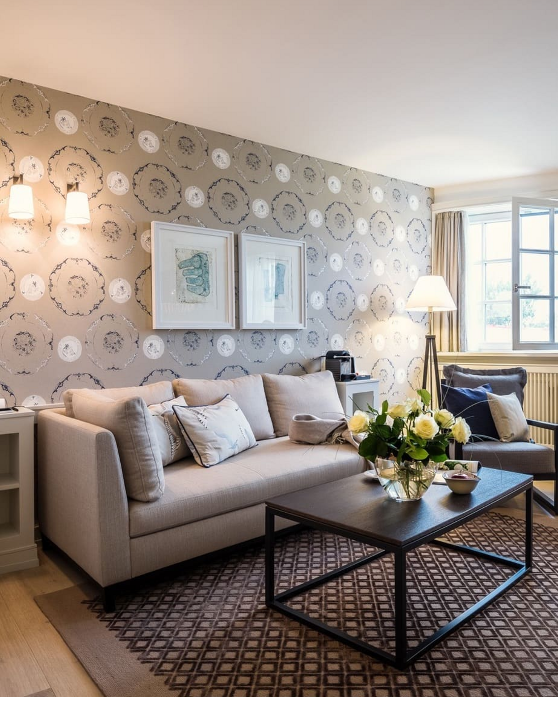 Cozy living room at Severin*s Resort with sofa, coffee table, bouquet of flowers and stylish wall decoration.