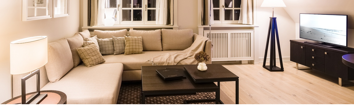 Innenansicht des Wohnzimmers mit großem Sofa im Studio Plus des Hotel Severin*s auf Sylt