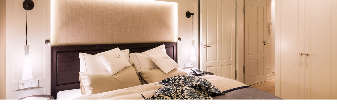 Elegantes Hotelzimmer mit Doppelbett, stilvoller Beleuchtung und luxuriösen Kissen im Severin*s Resort & Spa auf Sylt.