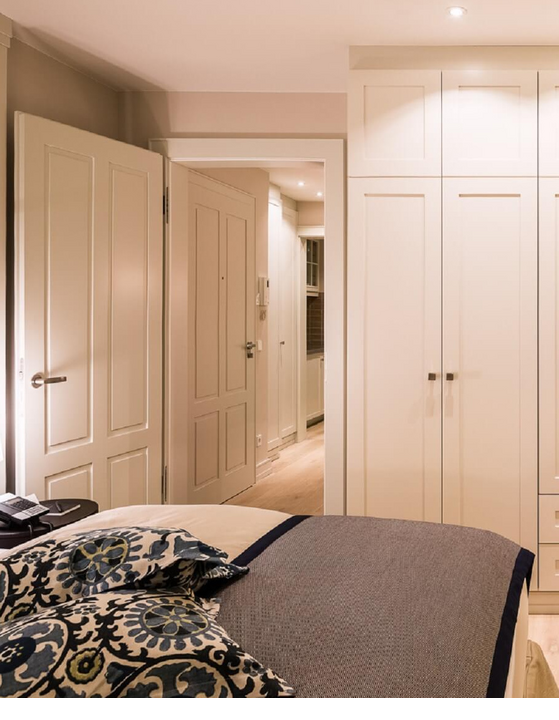 Elegant hotel room with stylish pillows, large bed, white wardrobes and subtle lighting at Severin*s Resort.