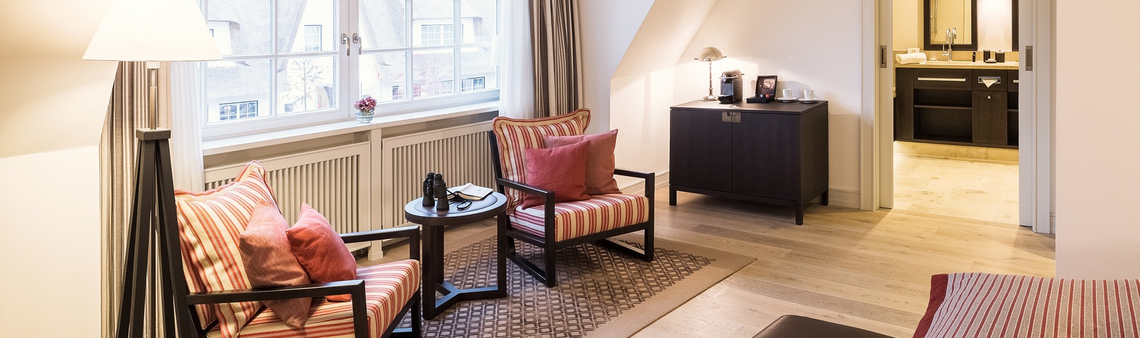Helles Hotelzimmer mit gemütlicher Sitzecke, großem Fenster, modernem Bad und stilvoller Einrichtung im Severin*s Resort & Spa.