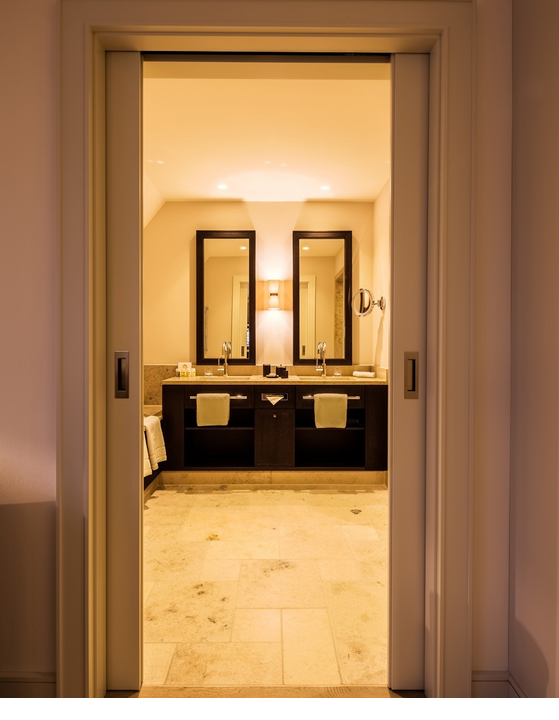 Luxuriöses Badezimmer im Severin*s Resort & Spa mit Doppelwaschbecken, großen Spiegeln und eleganter Beleuchtung.